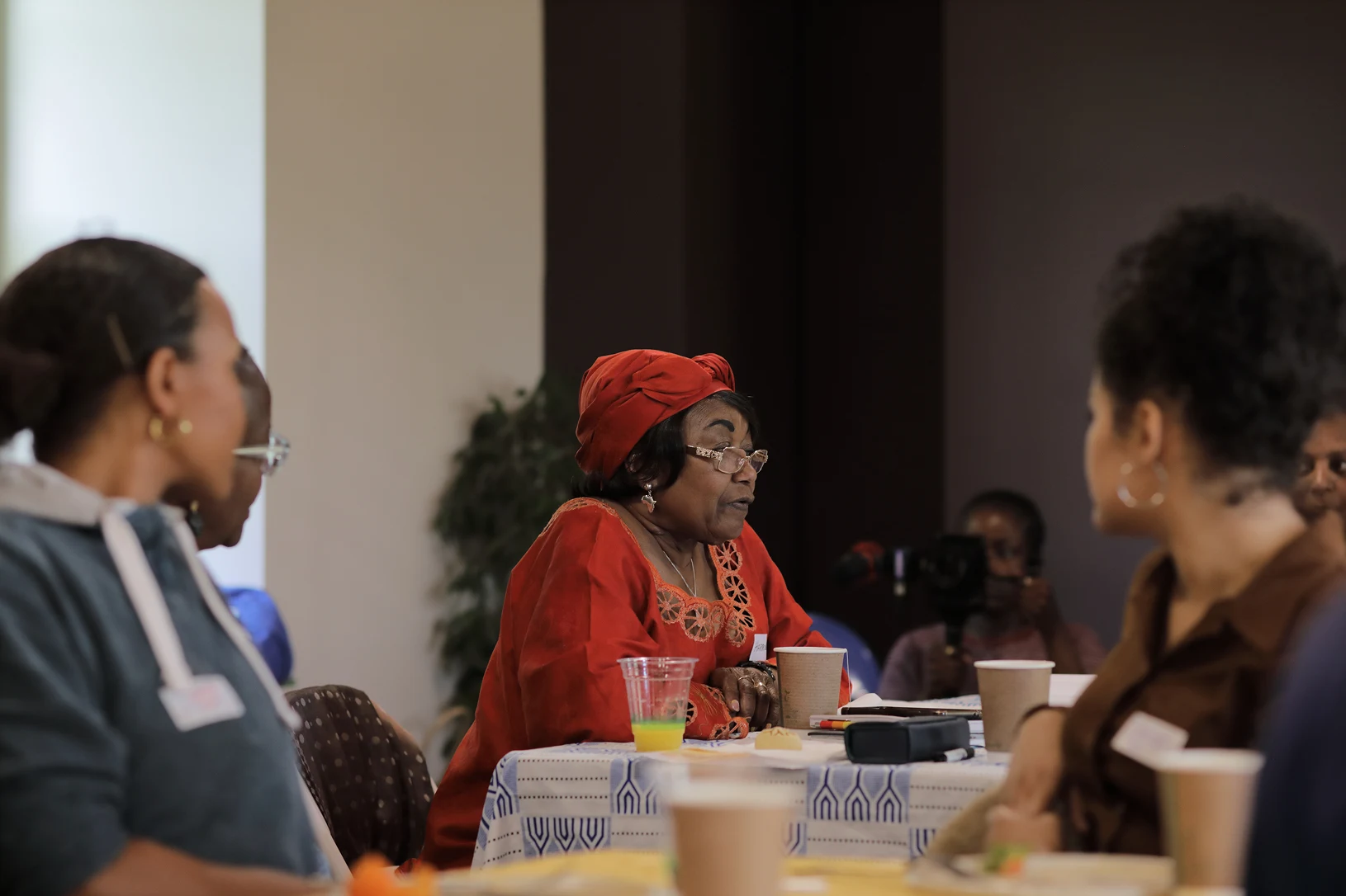 Event: Connecting African and Diasporic Solidarity Economy Practices 3 A woman speaking, surrounding by people listening intently